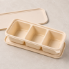 Open meal box with three deep compartments and matching lid in background
