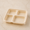 1100ml four compartment cornstarch food container with matching lid on beige surface