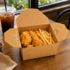 Steam-release kraft food box serving fried chicken and fries in café setting