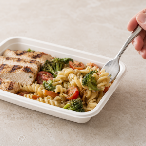Fork scooping pasta from a bagasse food tray with easy food access